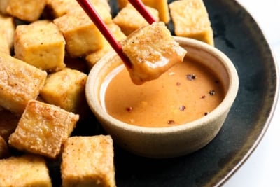 baked tofu dipped in sauce