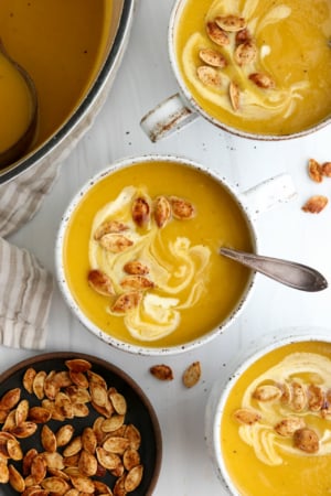 roasted pumpkin soup in mugs with pumpkin seeds on top